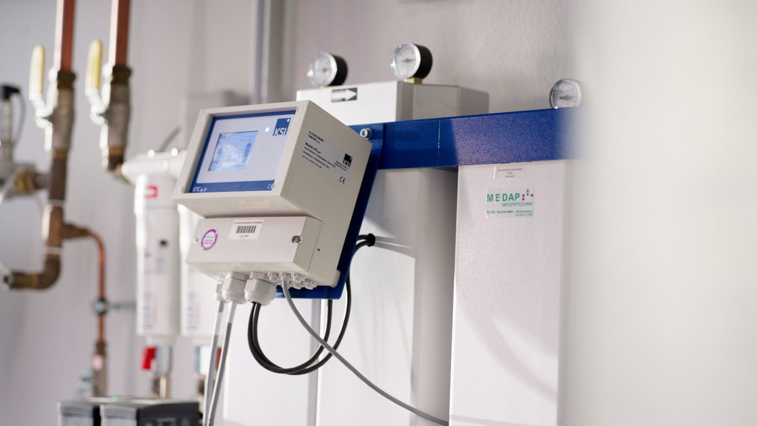 Druckluftanlage mit Steuergerät und Manometern in einem Technikraum.