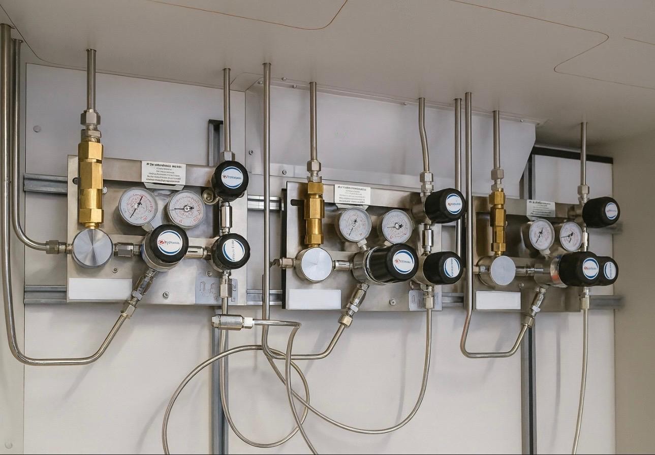 Gasverteiler mit mehreren Druckreglern und Manometern an der Wand montiert.
